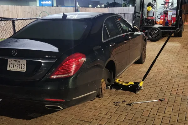 Mobile tire replacement on Mercedes-Benz S-Class by Houston Mobile Tire Service during nighttime roadside assistance.